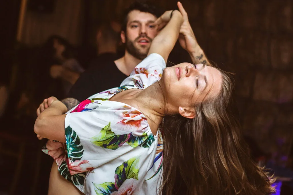 a woman dancing with a man behind her